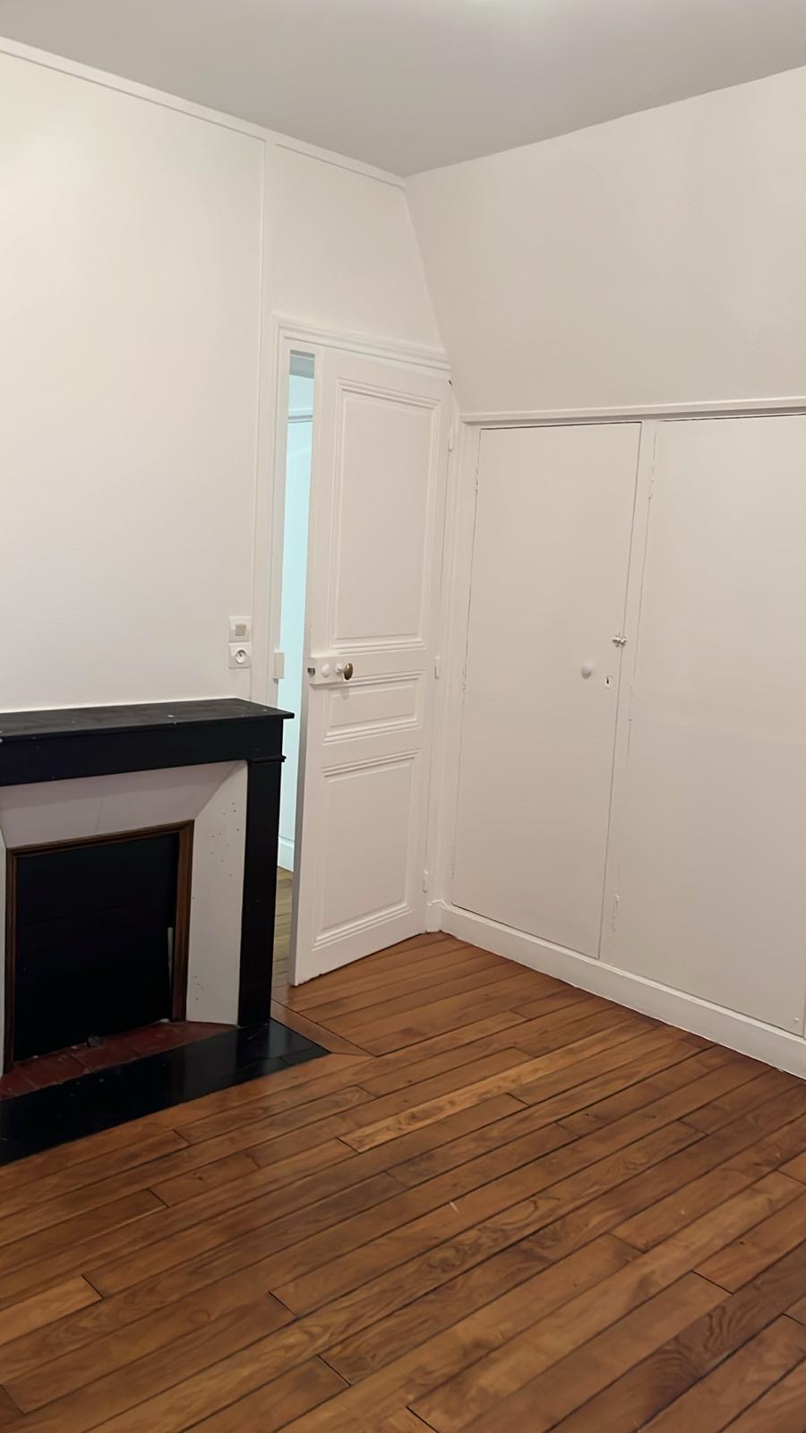 Pièce repeinte avec parquet et cheminée